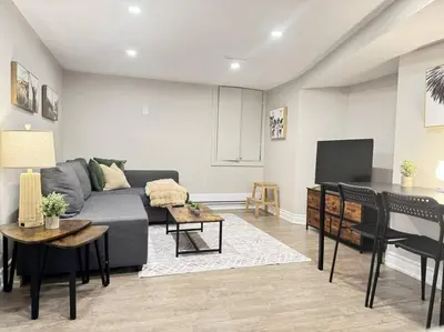a living room with a couch and a tv at Cosy Guest Suite Near Shops, Transit, Hwy and GO! in Mississauga