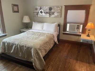 a bedroom with a bed and two lamps and a window at Exceptionally Close to the Falls Amazing Location & Complimentary Breakfast Delivered Daily to the Rental in Niagara Falls