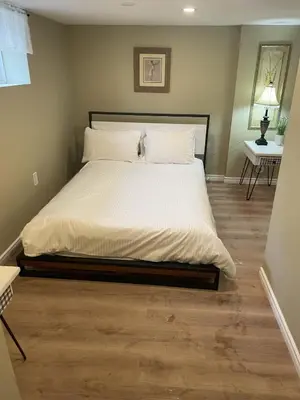 a bedroom with a large bed with a wooden floor at Exceptionally Close to the Falls Amazing Location & Complimentary Breakfast Delivered Daily to the Rental in Niagara Falls