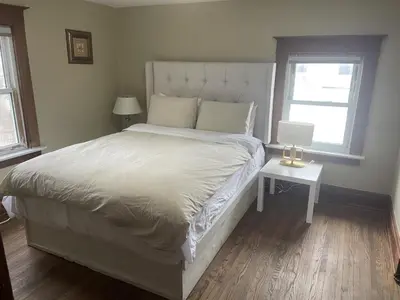 a bedroom with a bed and a table with a laptop at Exceptionally Close to the Falls Amazing Location & Complimentary Breakfast Delivered Daily to the Rental in Niagara Falls