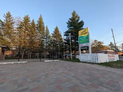 a sign in a parking lot next to a fence at Modern Tiny Wood Cottage 03 in Wasaga Beach