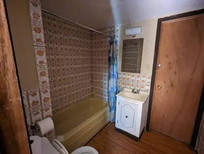 a bathroom with a tub and a sink and a toilet at Tiny Wood Cottage 05 in Wasaga Beach