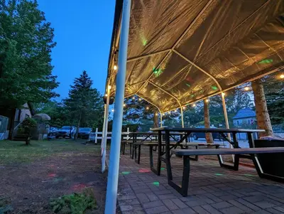 a group of picnic tables under a gazebo at Tiny Wood Cottage 05 in Wasaga Beach