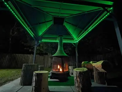 a fireplace under a green gazebo at night at Tiny Wood Cottage 05 in Wasaga Beach