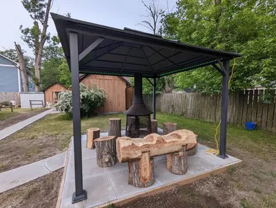 a picnic shelter with a bell in a yard at Tiny Wood Cottage 06 in Wasaga Beach