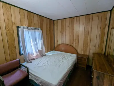 a small bedroom with a bed and a window at Tiny Wood Cottage 07 in Wasaga Beach