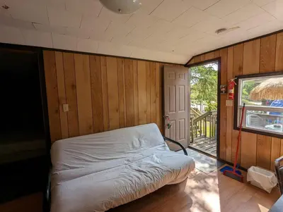 a bedroom with a bed in a room with wooden walls at Tiny Wood Cottage 12 in Wasaga Beach