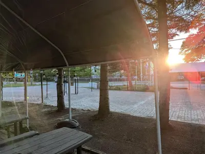 a picnic table in a park with the sun setting at Tiny Wood Cottage 14 in Wasaga Beach