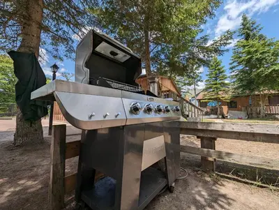 a stove top oven sitting next to a wooden fence at Tiny Wood Cottage 15 in Wasaga Beach