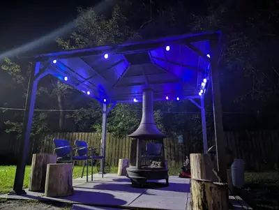 a blue gazebo with a fireplace under it at night at Tiny Wood Cottage 19 in Wasaga Beach