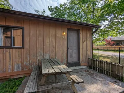 a wooden bench sitting in front of a cabin at Tiny Wood Cottage 21 in Wasaga Beach