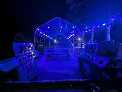 a picnic table in the dark with blue lights at Tiny Wood Cottage 21 in Wasaga Beach