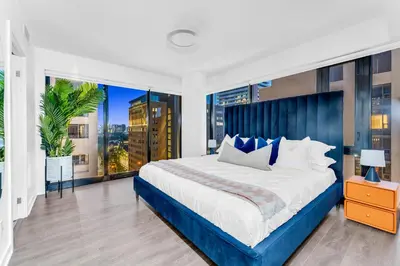 a bedroom with a large bed and large windows at The Royal 2 Bedroom Condo Yorkville in Toronto