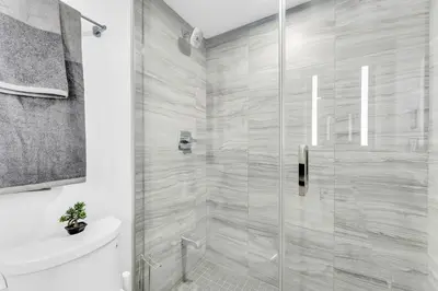 a bathroom with a shower with a toilet and a sink at The Royal 2 Bedroom Condo Yorkville in Toronto