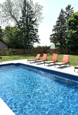 a group of chairs sitting next to a swimming pool at Alba Cottage with Brand New Pool in Queenston
