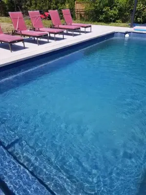a group of chairs sitting next to a swimming pool at Alba Cottage with Brand New Pool in Queenston