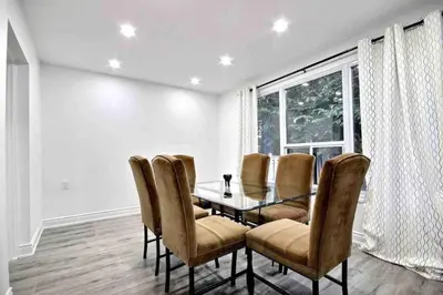a dining room with a table and chairs and a window at Modern Luxury Home next to Tim Hortons Field in Hamilton