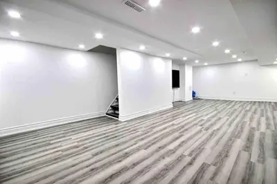 an empty room with white walls and wooden floors at Modern Luxury Home next to Tim Hortons Field in Hamilton