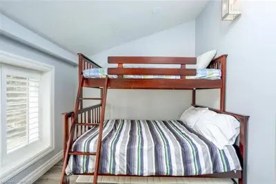 a wooden bunk bed in a room with a window at The Family Escape Townhome in Collingwood