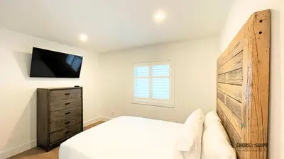 a bedroom with a large bed and a dresser at The 1883 Century Flat Suite in Collingwood