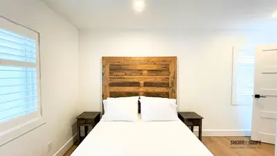 a bedroom with a bed and a wooden headboard at The 1883 Century Flat Suite in Collingwood