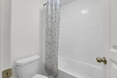 a white bathroom with a toilet and a shower at Spacious Family Friendly Vacation home in Brampton