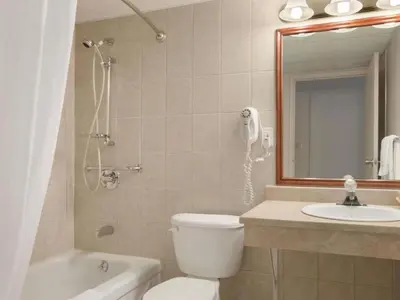 a bathroom with a toilet and a sink and a mirror at Travelodge by Wyndham Cambridge - Waterloo in Preston