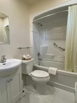 a white bathroom with a toilet and a sink at Motel 400 & Suites in Innisfil