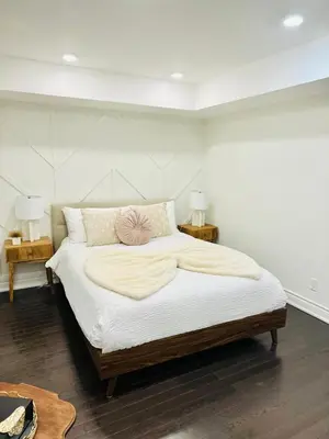 a bedroom with a large bed with a pink flower on it at Dufferin Serenity Suite in Toronto