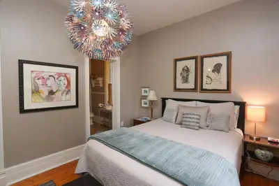 a bedroom with a large bed and a chandelier at Danby House in Markdale