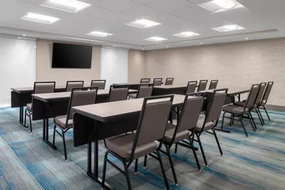a conference room with tables and chairs and a screen at Home2 Suites By Hilton Kitchener in Kitchener