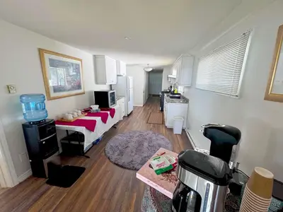 a living room with a bed and a kitchen at Charming Cottage on Lake Simcoe in Orillia