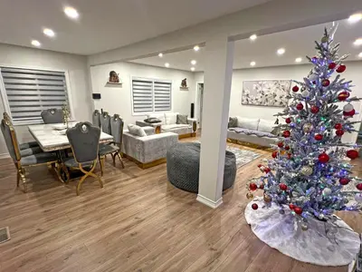 a living room with a christmas tree and a dining room at Charming Cottage on Lake Simcoe in Orillia