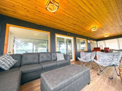 a living room with a couch and some chairs at Charming Cottage on Lake Simcoe in Orillia