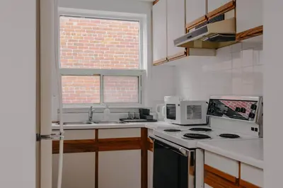 a kitchen with a sink and a stove and a window at Lum The Queen in Toronto