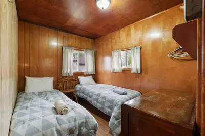 two beds in a room with wooden walls at Dive into Nature in Bailieboro