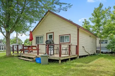a small house with a picnic table on the porch at Peaceful Getaway in Bailieboro