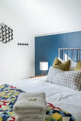 a bedroom with a large bed with a blue wall at The Marigold - Gorgeously remodelled PEC farmhouse in West Lake
