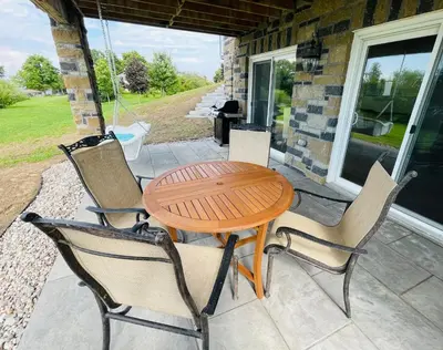 a wooden table and chairs on a porch with a table at Lakeside Maison in Hillier