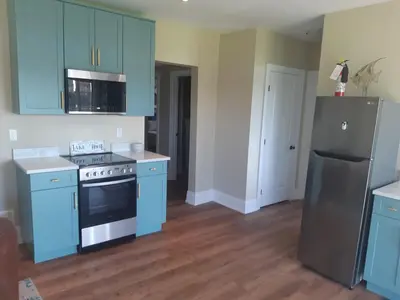 a kitchen with blue cabinets and a stove and refrigerator at Lakeside Maison in Hillier