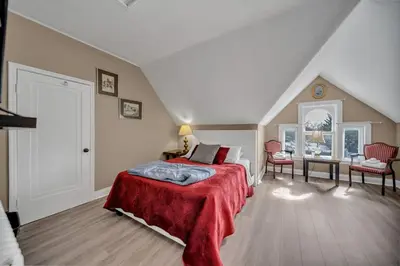 a bedroom with a bed with a red blanket at Marmora and Lake Inn and Victorian Diner-2025 Group Reunion Home for up to 32 guests in Marmora