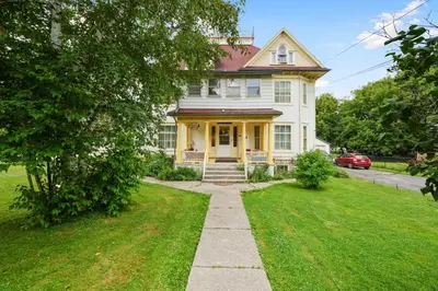a white house with yellow trim and a driveway at Marmora and Lake Inn and Victorian Diner-2025 Group Reunion Home for up to 32 guests in Marmora