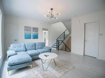 a living room with a blue couch and a table at Casa Lago 5 Bed Waterfront House in Innisfil