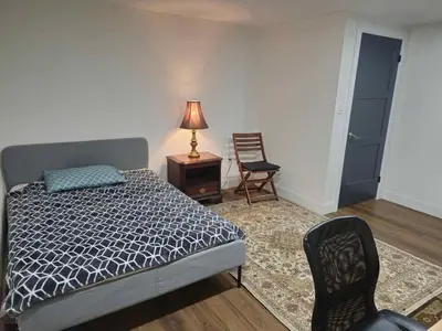a bedroom with a bed and a lamp and two chairs at Forest city House -Rooms in a family style in London