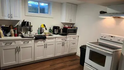 a kitchen with white cabinets and a stove top oven at Forest city House -Rooms in a family style in London