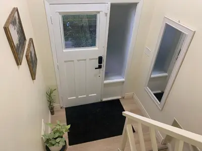 a hallway with a white door and a black rug at Millpond Basement Units in Richmond Hill