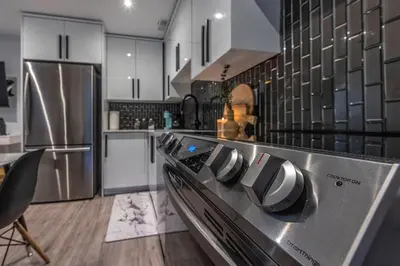 a kitchen with a stainless steel stove top oven at Cozy Modern Custom Built-Free Pkg-Game Room-Heated Floors in Toronto
