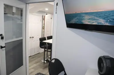 a room with a flat screen tv on a wall at Garden 2 BR Apt - Free Parking Wifi Laundry Workstation in Brampton