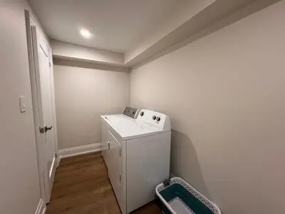 a small laundry room with a washer and dryer at 2 Bedroom 1 Parking Basement Unit in Richmond Hill