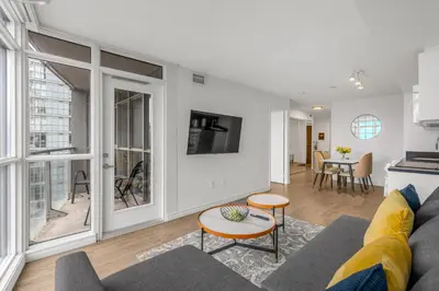 a living room with a couch and a table at Beautiful 2 Bedroom Downtown Toronto Condo with free parking in Toronto